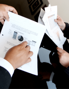 Businessmen showing papers with charts on them