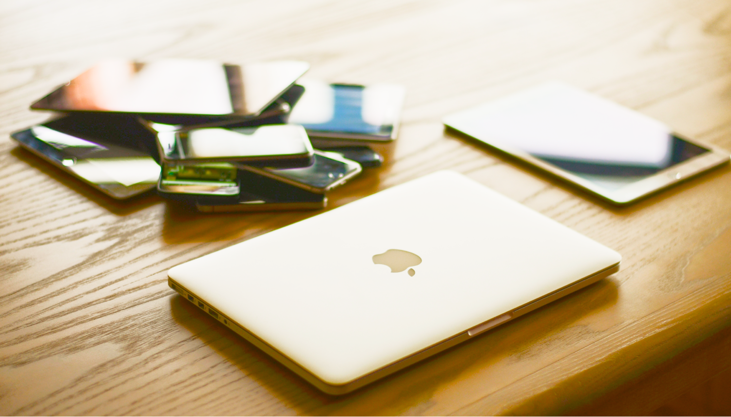 Cellphones, laptops, and tablets laid out on a table